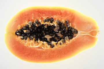 top view of ripe exotic papaya half with black seeds isolated on white