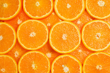Slices of oranges as a background, top view.