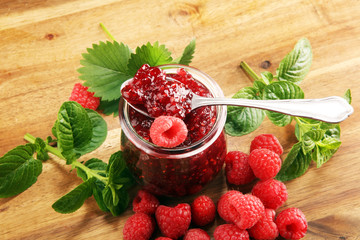 raspberry jam with fresh raspberries and mint. marmalade on spoon and jar