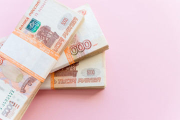 Stack of 5000 rubles packs isolated on pink. The concept of wealth, profits, business and finance. Stack money in the five thousandth bills banknotes. A lots wads of money, many cash