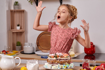 Little girl is making a homemade cake with an easy recipe at kitchen against a white wall with shelves on it.