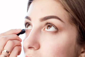 Makeup artist makes evening make-up of young girl brown-haired. Casual outfit. Backstage of process.