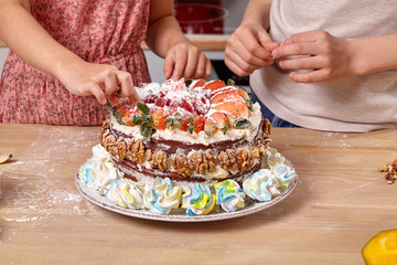 Little friends are making a cake together at a kitchen.