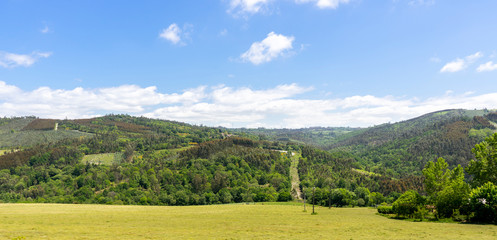 Landscape of a plain with high mountains in the background and a clear sky with clouds. Galicia, Spain.
