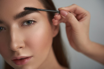Obraz premium Tranquil woman with nude make-up is having brows styled