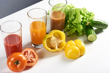 Fresh juices and vegetables isolated on grey background