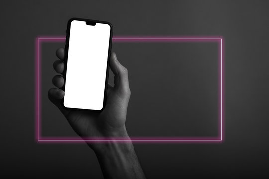 Hand holding modern smartphone with a blank white screen and neon light glow