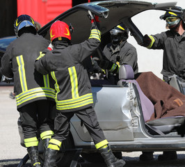 firefighters open a damage car
