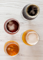Assorted beers on a white wooden background, top view. Overhead, from above. Close-up.