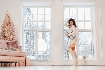 Beautiful young girl in white dress posing on camera. Christmas concept