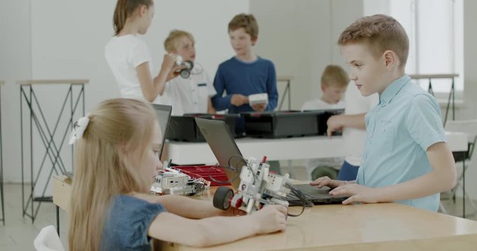 Curious kids working on a functional programable robot during robotics class at school. 4K UHD 60 FPS SLOW MOTION
