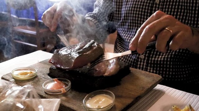 meat with smoke on stone with sauces in restaurant