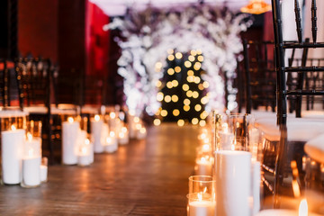 Wedding ceremony decorations in loft grunge surround. Light bulb garland, candles, glass, chairs and candlesticks. Ceremony in purple color. Exit registration inside.