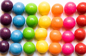 Top view of colorful candies on white background.