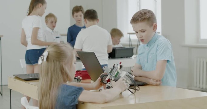 Curious kids working on a functional programable robot during robotics class at school. 4K UHD 60 FPS SLOW MOTION