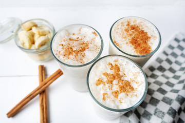 Banana smothie or milkshake with cinnamon on white  background
