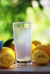 Lemon water, lemonade in glass with sliced lemons