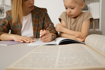 Doing tasks and studying concept. Sitter with girl writing homework