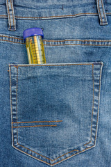 Close Up View to Test Tube With Urine Sticking Out From a Blue Jeans Pocket
