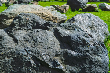 Garden of stones on the green lawn in the park.