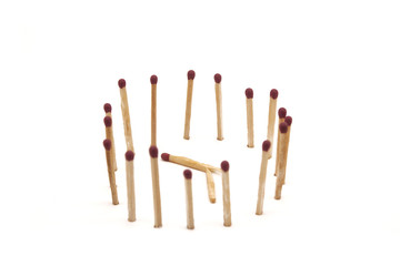 matches stand in the circle around a broken match on a white background