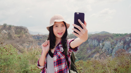 Blogger Asian backpacker woman record vlog video on top of mountain, young female happy using mobile phone make vlog video enjoy holidays on hiking adventure. Lifestyle women travel and relax concept.