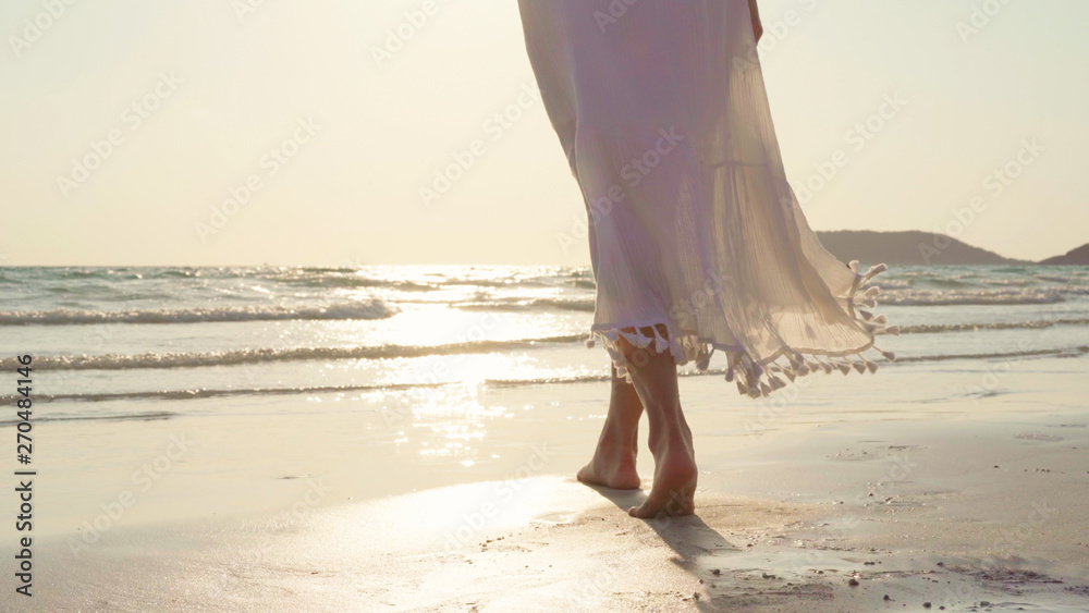 Wall mural young asian woman walking on beach. beautiful female happy relax walking on beach near sea when suns