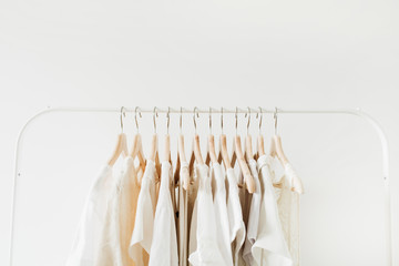 Minimal fashion clothes concept. Female blouses and t-shirts on hanger on white background. Fashion...