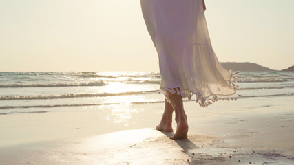 Young Asian woman walking on beach. Beautiful female happy relax walking on beach near sea when sunset in evening. Lifestyle women travel on beach concept.