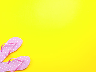 Top view image of pink flip flops on yellow background. Summer trevel and vacation concept