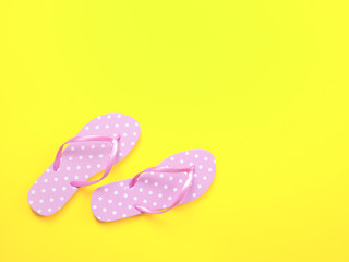 Top view image of pink flip flops on yellow background. Summer trevel and vacation concept