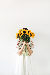 Young pretty woman with sunflowers bouquet on white background.