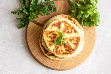 Frying flatbread filled with fresh herbs and cheese. Khychiny or qutab - traditional caucasian or Azerbaijani flatbread