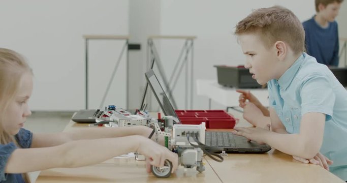 Curious kids working on a functional programable robot during robotics class at school. 4K UHD 60 FPS SLOW MOTION