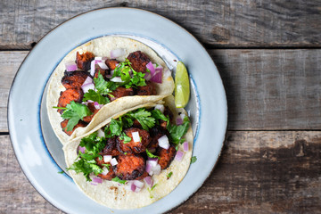 Mexican food: Delicious red chorizo tacos on wooden background