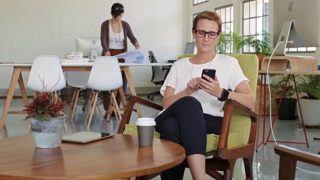 Woman in office looks at cellphone