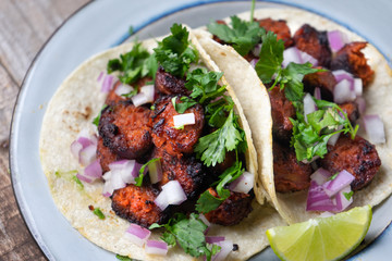 Mexican food: Delicious red chorizo tacos on wooden background