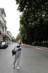 Fototapeta premium Stylish young student stands on the street and enjoys life