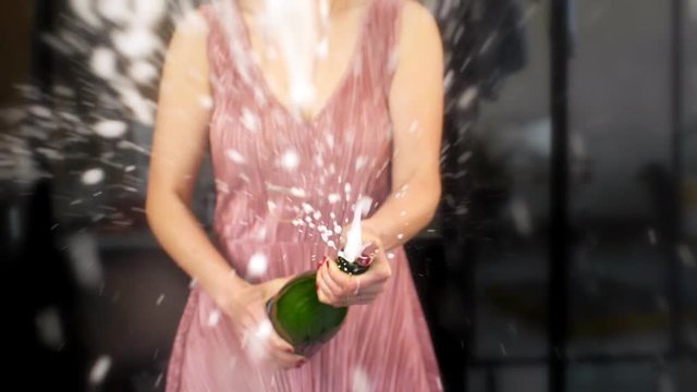 Woman In Party Dress Spraying Champagne Towards Camera