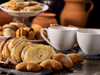 Cookies heart shape, sand rolled biscuit and cinnamon stick on wood table served dessert spoon at kitchen in rustic style. Morning sun flare. Several recipes for baking.