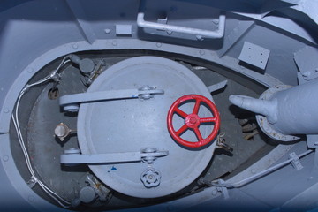 Cover of the upper manhole of a submarine with a red rotary valve wheel
