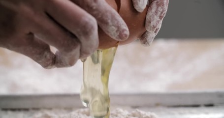 Breaking egg over flour