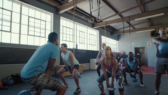 Group of people exercising with kettlebell gym class