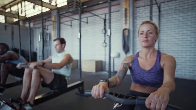 People working out in gym on rowing machines