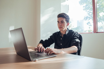 Portrait of boy working with dark shirt in office