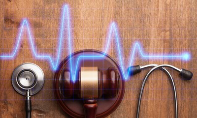 Gavel and stethoscope on wooden background, symbol photo for bungling and medical error