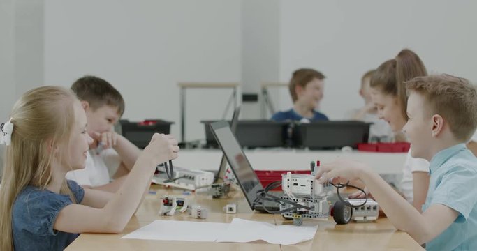 Curious kids working on a functional programable robot during robotics class at school. 4K UHD 60 FPS SLOW MOTION