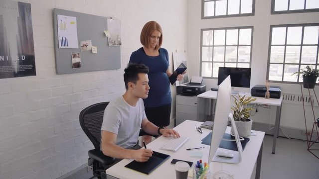 Pregnant woman in office with colleague