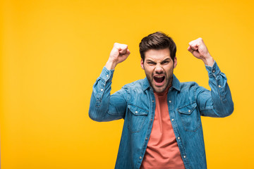 excited handsome man gesturing with hands Isolated On yellow