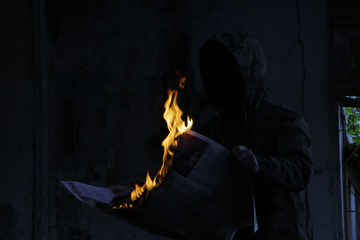 man reading the lit newspaper image